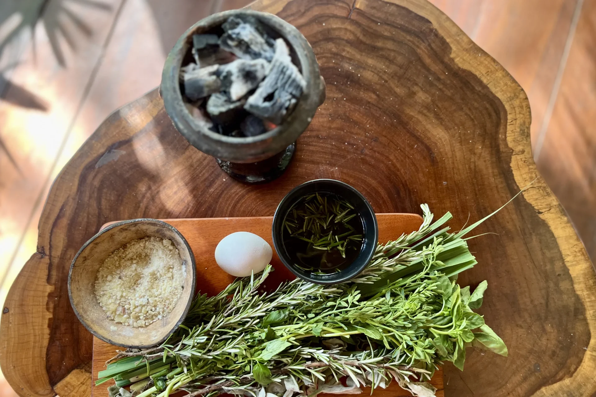 A still-life image of traditional Mayan healing materials—copal resin, sacred Mayan herbs, and fresh eggs—arranged with intention and reverence.