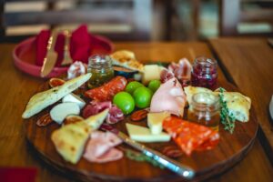 A cheese and charcuterie board, with seasonal jam, walnuts, and grapes.