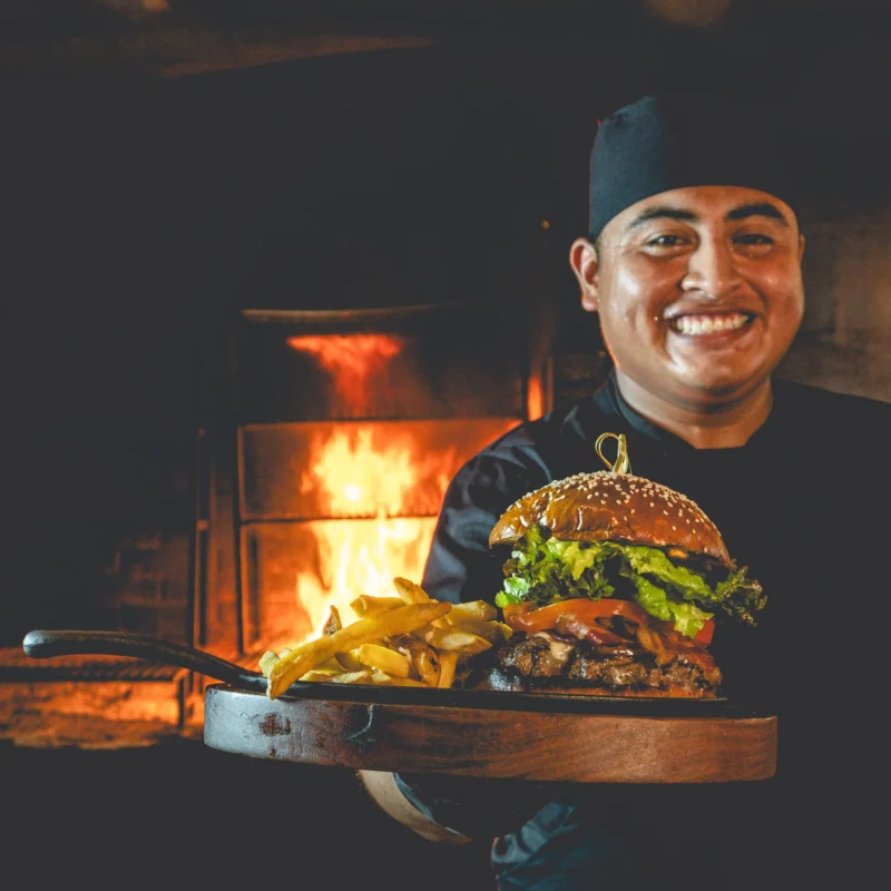Ziggy burger and beef barbecue A smiling chef holding the Ziggy burger and Beef barbecue accompanied by french fries