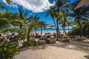 A view of the sea from Ziggy Beach Club in Tulum with people relaxin gin the sun and shade