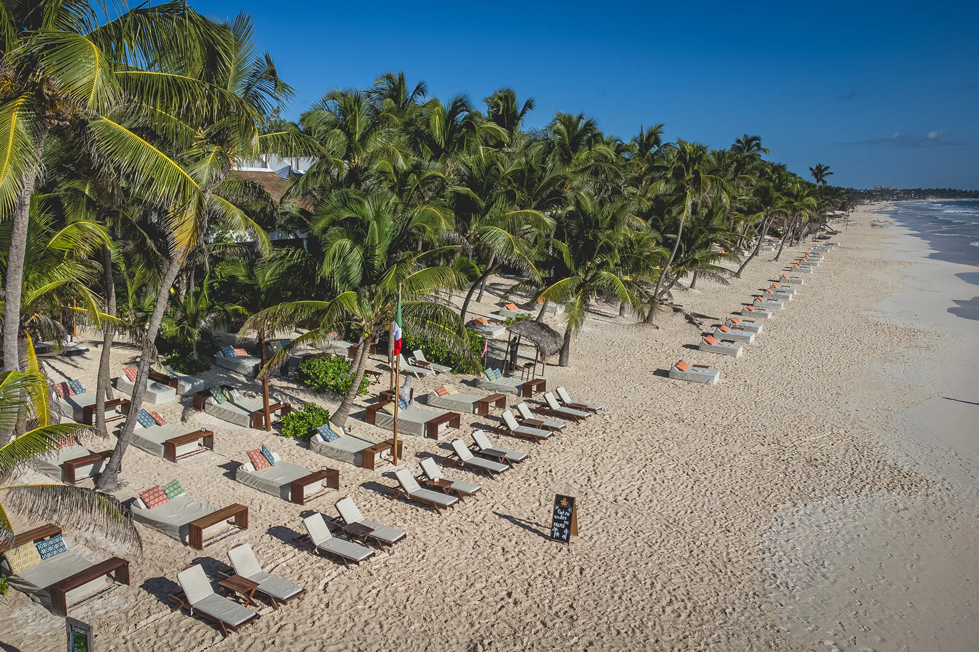 an aerial view of Ziggy Beach Club in Tulum with sunbeds, loungers, palm trees 